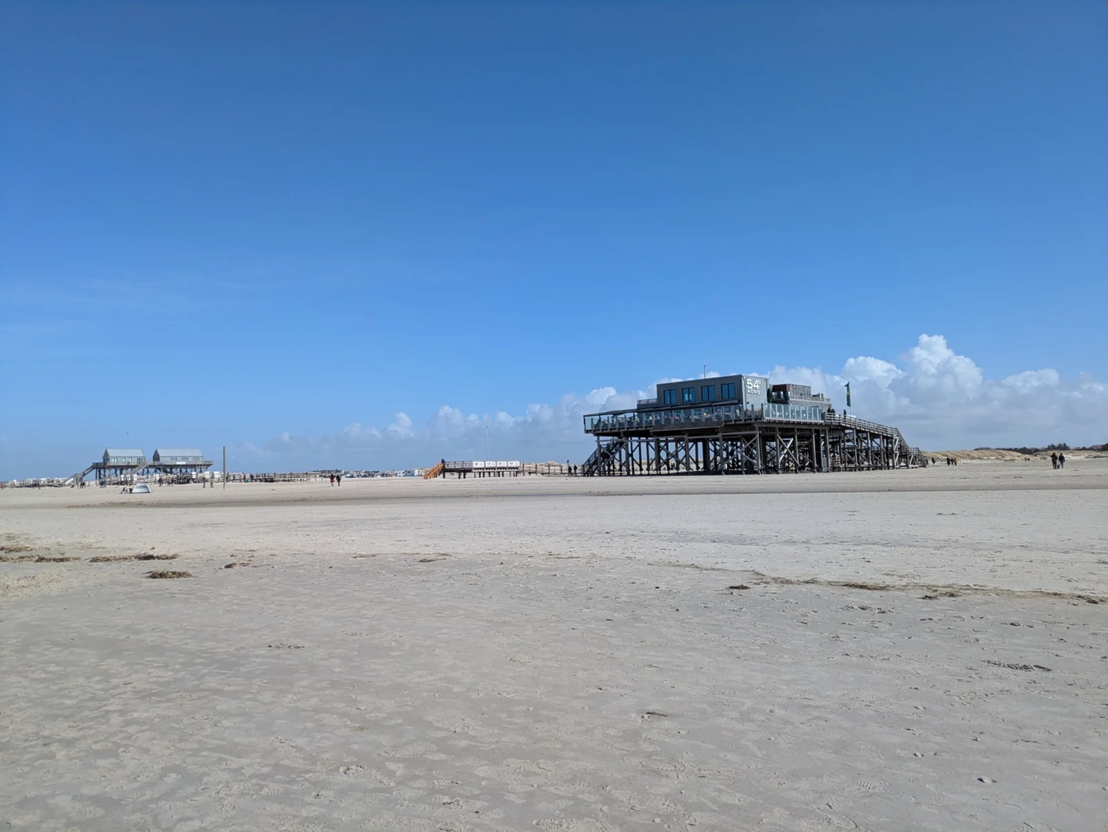 Die typischen Pfahlbauten am weiten Sandstrand von Sankt Peter-Ording