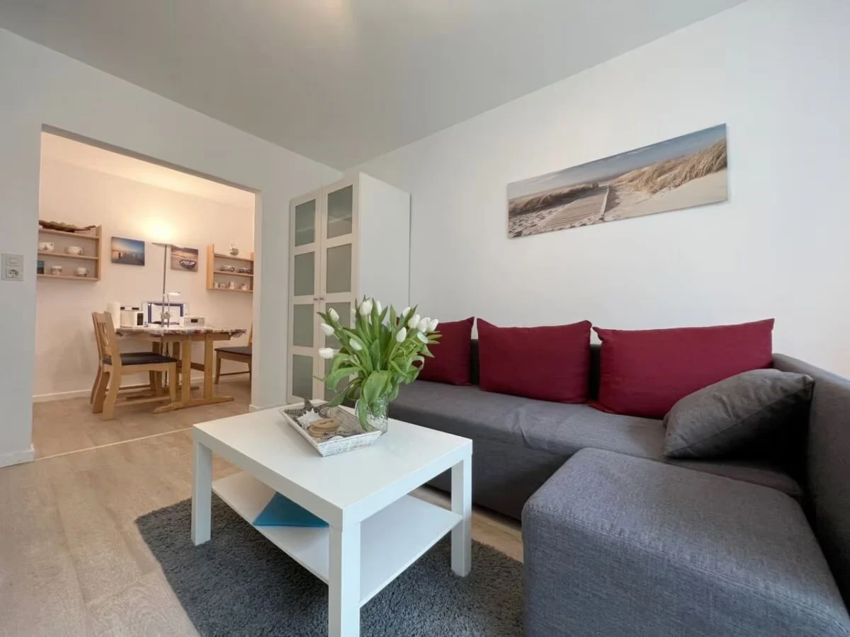 Wohnzimmer der Ferienwohnung Lütt Witthues mit Sofa und maritimen Details